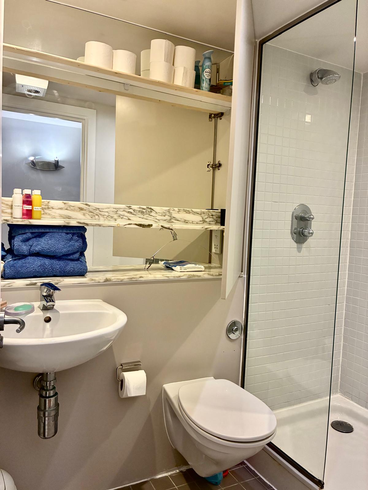 Clean, well-lit bathroom with marble shelf