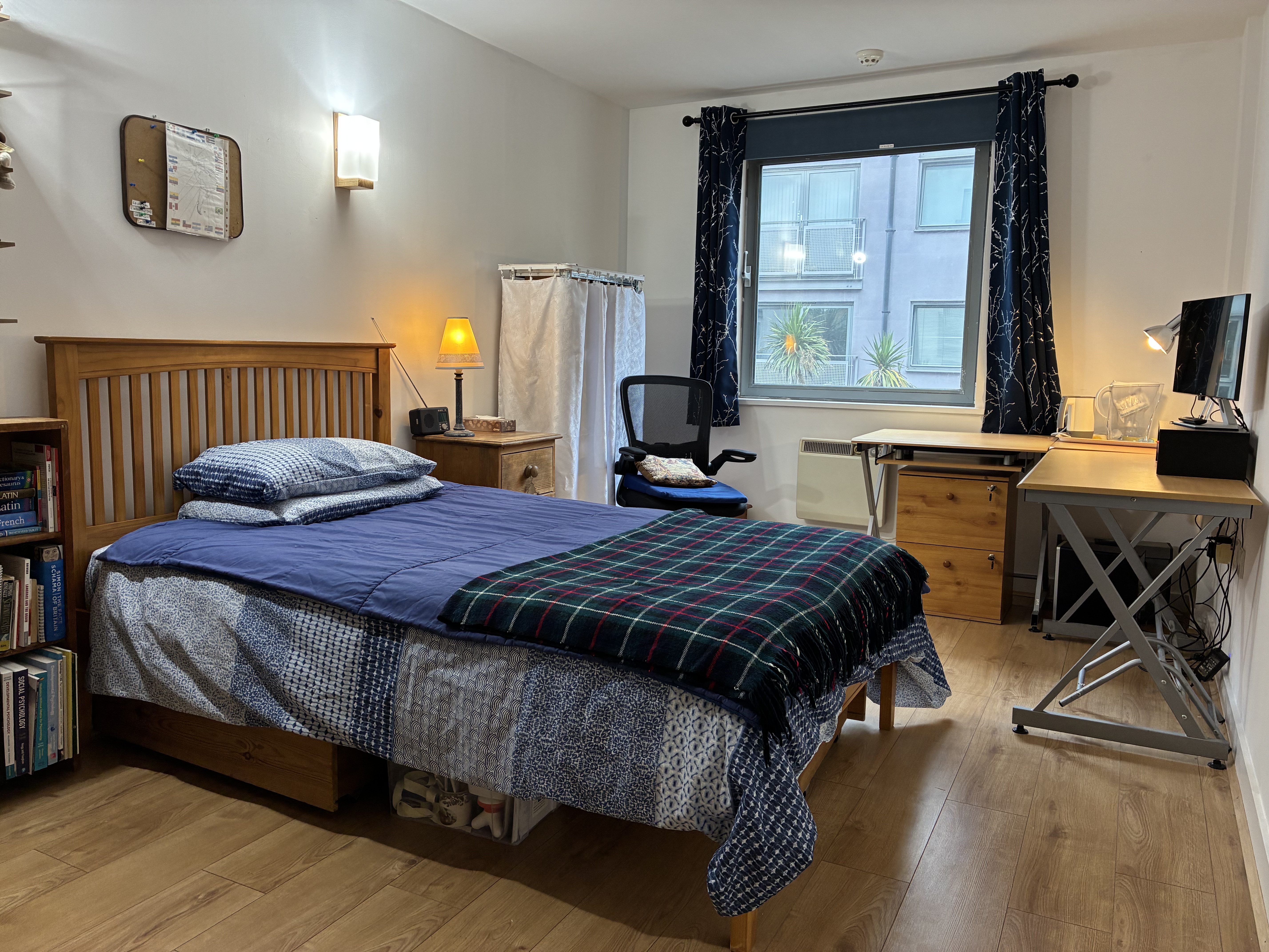 Double bedroom with blue curtains and warm lamp