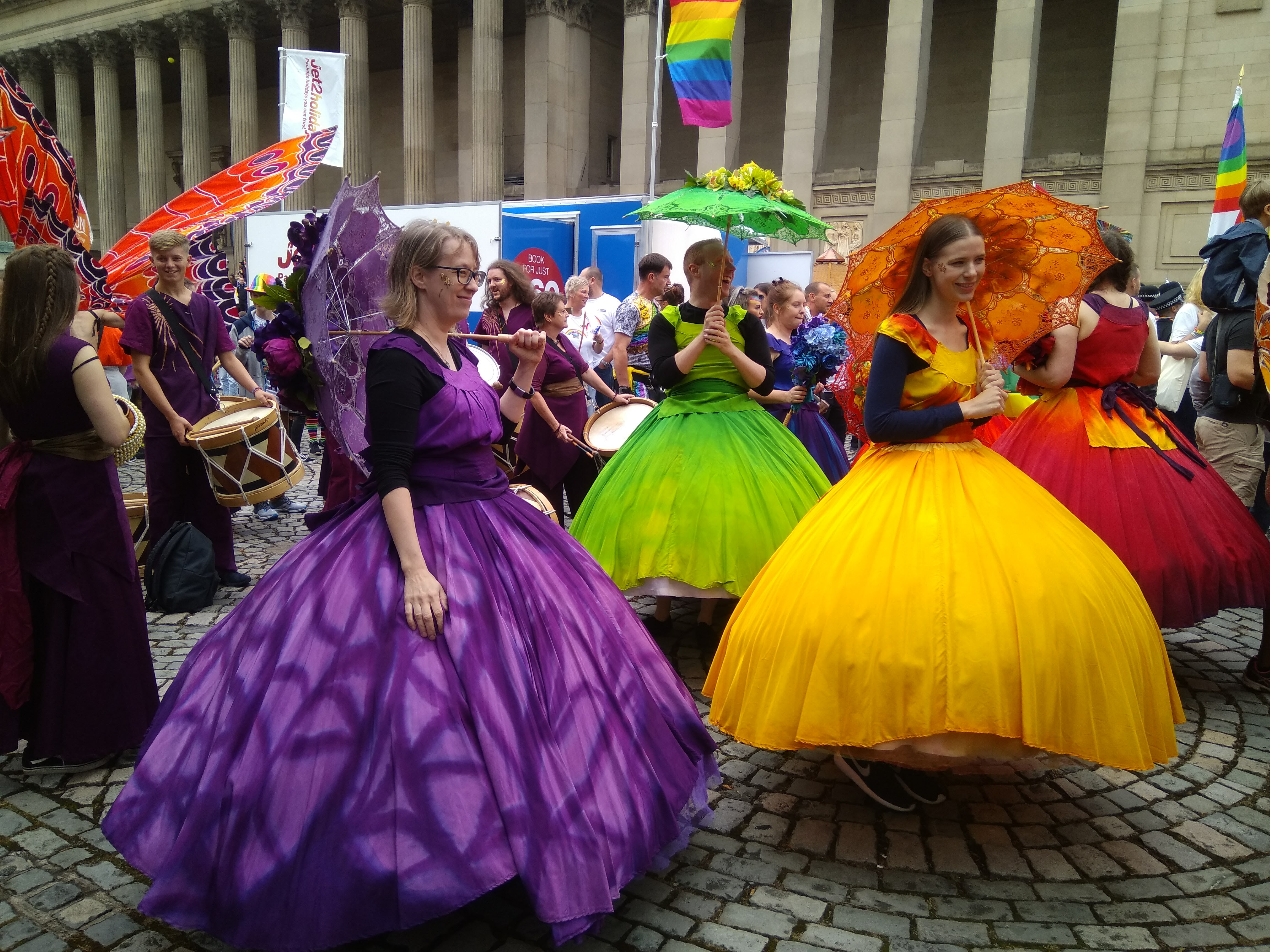 Colourful street performers in ballgowns at a city parade